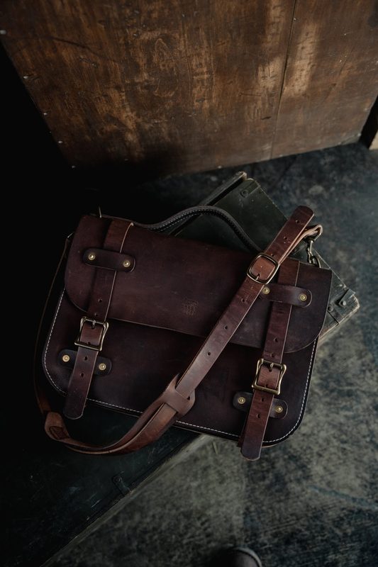 Dark brown leather briefcase bag on a stone floor