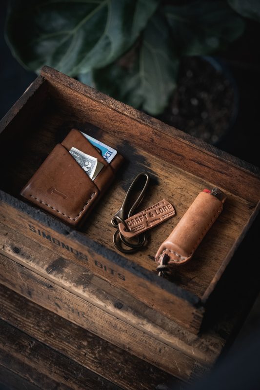 Leather card wallets and a key fob in a wooden box