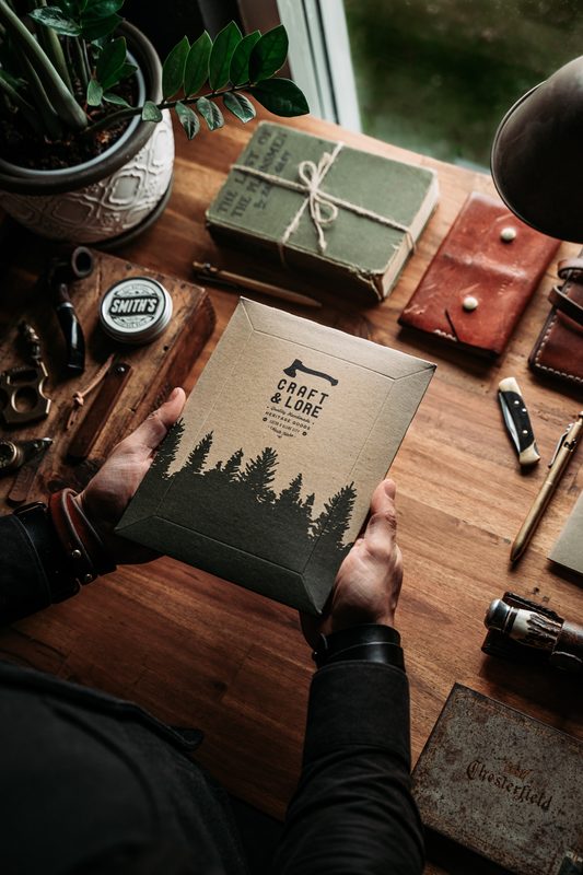 Hands opening a Craft & Lore package at a workbench