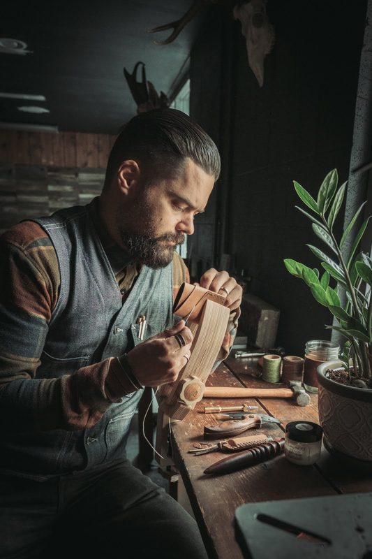 Leatherworker at a bench shaping a piece of leather