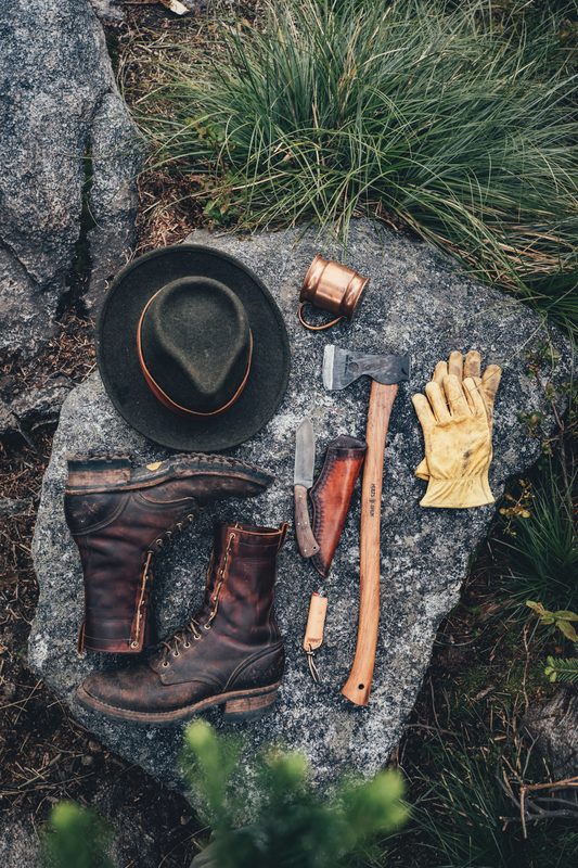 Hat, boots, knife and gloves laid out on a granite slab