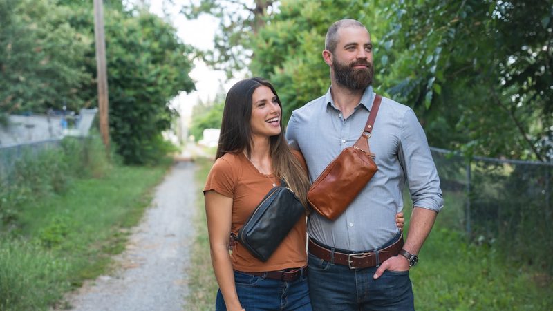 Couple on a country path wearing leather sling bags