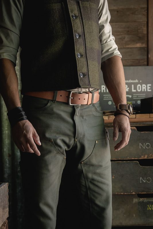 Leather belt and canvas work pants in a workshop