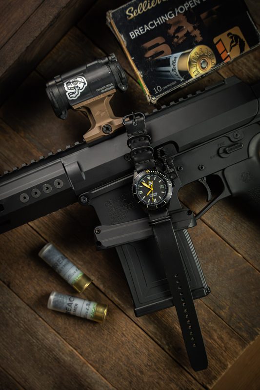 Black watch on a rifle with shotgun shells and a book